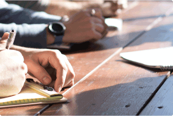 Employees writing on a pad in a meeting