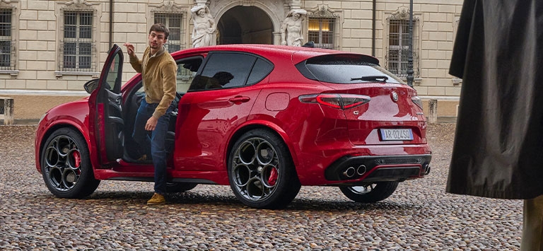Man getting out of a Red Alfa Romeo Stelvio